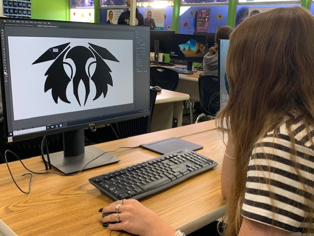 Student designing logo on computer with Adobe Illustrator